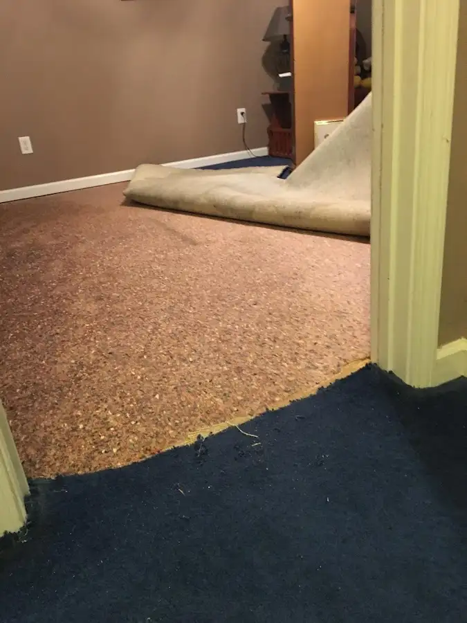 Carpet pad removal revealing water damage during Water Mitigation Services in Grayson Valley